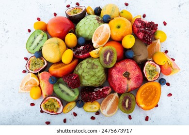 Group of Exotic fruits including, rose kiwi, pomegranate, passion fruit, cherimoya, Tamarillo, tiger lemon, Custard Apple, kumquat, red apple. Unusual tropical fruits on white textured background. - Powered by Shutterstock