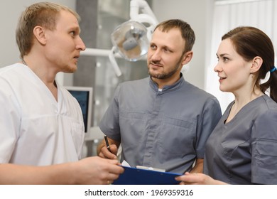 A Group Of Experienced Dentists Discuss A Dental Treatment Plan In The Office Of A Modern Dental Clinic