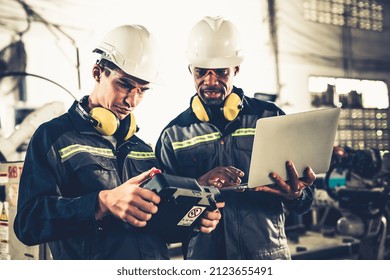 Group Of Factory Job Workers Using Adept Machine Equipment In A Workshop . Industry Manufacturing And Engineering Technology Concept .