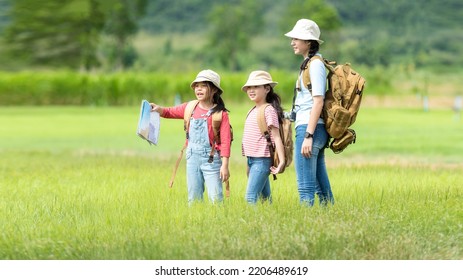 Group Family Children Checking Map In The Jungle Adventure.   Asia People Tourism For Destination Leisure Trips For Education And Relax In Nature Park.  Mountain Background.  Travel Vacations