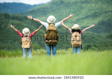 Group family children travel nature trips raise arms and standing see mountain outdoors, adventure and tourism for destination leisure trips for education and relax in nature park. Travel vacations 