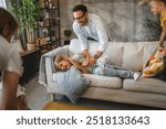 A group of family members are seen interacting and enjoying themselves on a comfortable couch in their well-decorated living room, symbolizing happy family time and playful moments