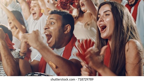 Group Of Fans Cheer For Their Team Victory On A Stadium Bleachers. They Wear Casual Fan Clothes.