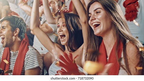 Group Of Fans Cheer For Their Team Victory On A Stadium Bleachers. They Wear Casual Fan Clothes.