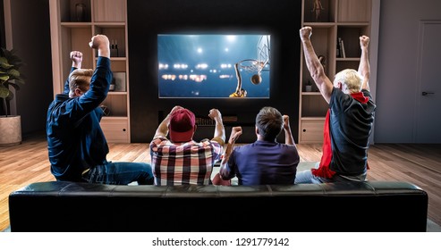 A Group Of Fans Is Watching A Basketball Moment On The TV And Celebrating A Victory, Sitting On The Couch In The Living Room. The Living Room Is Made In 3D.