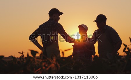 A group of farmers in the field, shaking hands. Family Agribusiness