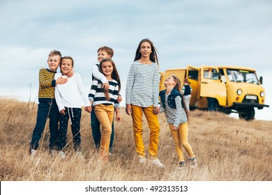 Group Of Fashion Children Wearing Same Style Clothing Having Fun In The Autumn Field. Fall Casual Outfit In Navy And Yellow Colors. 7-8, 8-9, 9-10 Years Old Models.