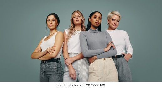 Group of fashionable women standing together in a studio. Diverse women looking at the camera while standing against a studio background. Four female friends looking confident in a studio. - Shutterstock ID 2075680183