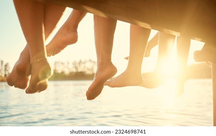 Group, feet on water and friends together at ocean, pier or outdoor in summer, vacation or freedom in holiday break. Teen, foot and children to relax at the lake, harbor or river on the weekend - Powered by Shutterstock