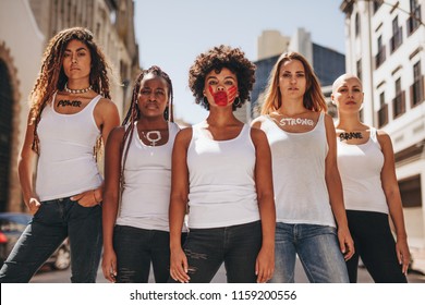 Group of female activists in dress code demonstrating outdoors. Protesting for women rights and equality.