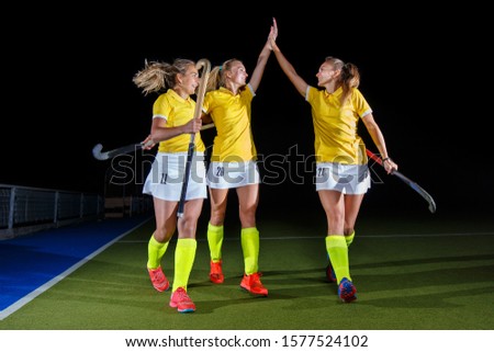 Group of female field hockey players celebrate the victory