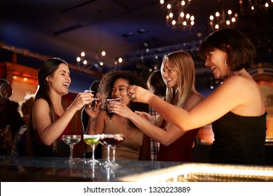 Group Of Female Friends Drinking Shots In Cocktail Bar Together - Powered by Shutterstock