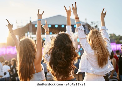 Group of female friends enjoying live music on sunny beach festival. Girls dance, celebrate with hands up in summer vibe. Casual fun, youth culture, outdoor event by sea. Friendship, lifestyle moment. - Powered by Shutterstock