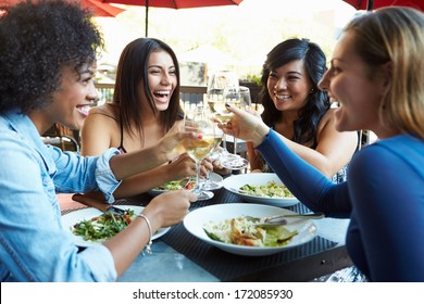 Group Of Female Friends Enjoying Meal At Outdoor Restaurant