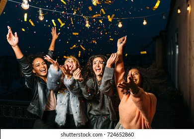 Group of female friends under confetti. Women having fun outdoors.