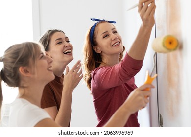 Group of female friends using paint roller to decorate walls in they new home.	
 - Powered by Shutterstock