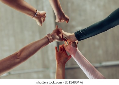 Group Of Female People Stacking Hands Indoors At Sport Gym - Teamwork And Fitness Concept