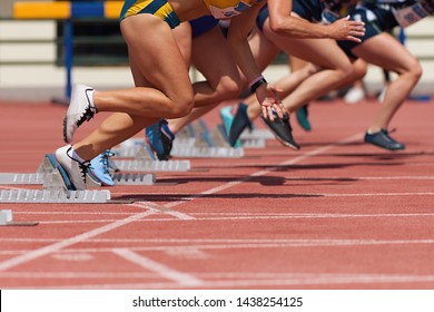 Group of female track athletes on starting blocks - Powered by Shutterstock