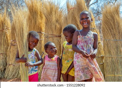 Group of few happy girls and a boy playing with the thatching grass in a village in Botswana