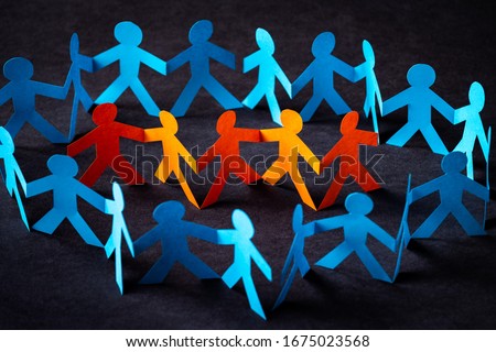 Group of figures of one color surrounded by figures by another color. Paper cut concept.