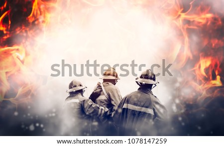 Group of firefighters fighting a fire, They are in the midst of fire and smoke.