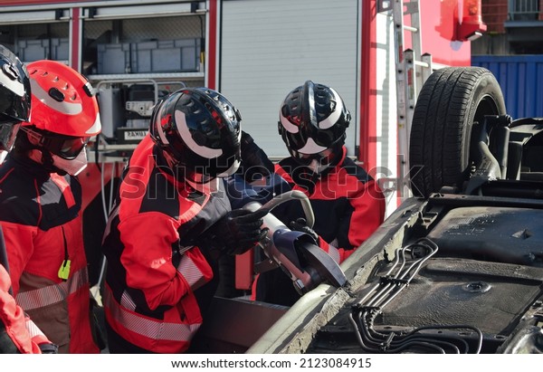 Group of firefighters wearing uniforms and
helmets carry out a rescue in a car
accident