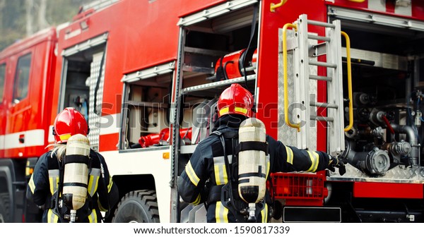 Group of Fireman in action. Firefighter in uniform,\
fire brigade team work