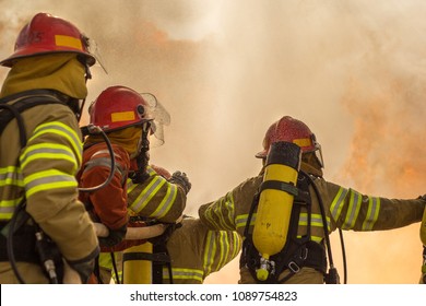 A group of firemen attacking a fire with water. some brave firemen doing teamwork against fire. firefighter team work.