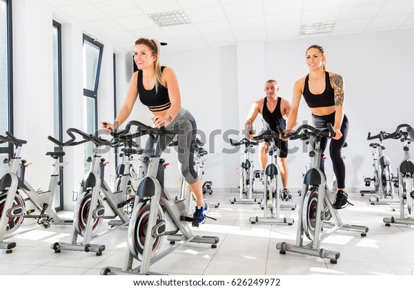 Group of fit people training at class. Cardio\
workout. Indoor cycling.