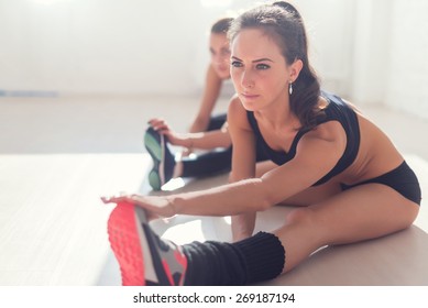 Group Of Fit Women Working Stretching Leg Muscles Of Back To Warm Up At Gym Fitness, Sport, Training And Lifestyle Concept