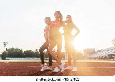 Group of fit young sportswomen standing on athletics stadium and posing. - Shutterstock ID 485427823