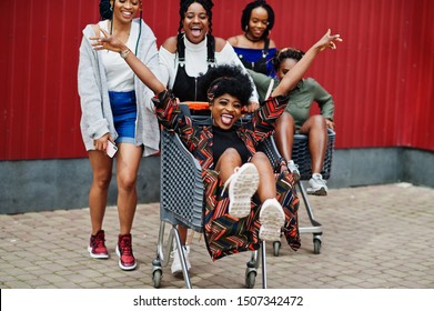 Group of five african american woman with shopping carts having fun together outdoor.