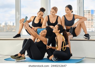 group of five and cheerful multicultural women in sportswear taking selfie after yoga class - Powered by Shutterstock