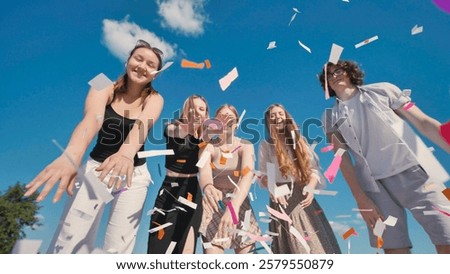 Group of five exuberant high school students joyfully tossing vibrant confetti in the air to celebrate their graduation day