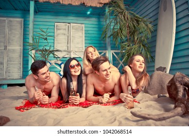 Group Of Five Friends Celebrating In Their Summer Beach House