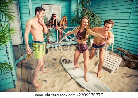 Similar – Young friends holding woman on top of surfboard