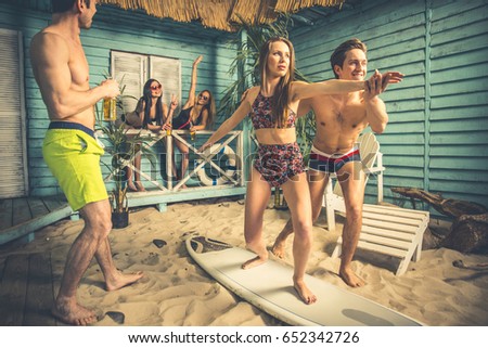 Similar – Young friends holding woman on top of surfboard