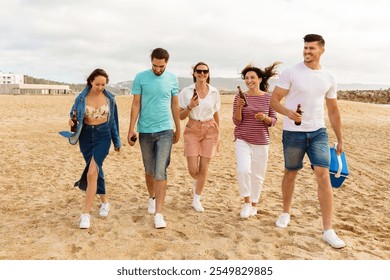 A group of five friends strolls along the sandy beach, chatting and holding drinks. The sun shines brightly as they enjoy their time together, creating a joyful atmosphere. - Powered by Shutterstock