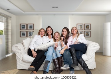 A Group Of Five Happy Women Of Different Ages Laughing In The Living Room