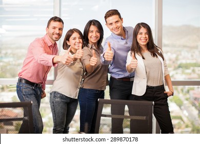 Group Of Five Latin People In Casual Attire Giving Their Thumbs Up And Smiling