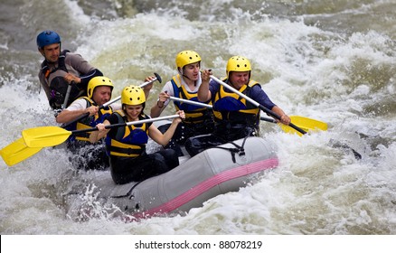 Group Of Five People Whitewater Rafting In River