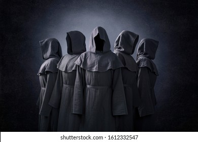 Group of five scary figures in hooded cloaks in the dark - Shutterstock ID 1612332547