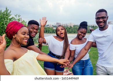 group of five smiling african-american men and women walking outside cloudy weather near the lake,exchange students in Russia