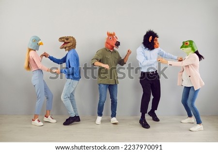 Group of five strange people in animal disguise dancing and having fun together. Team of young men and women wearing funny wacky animal masks having fun at crazy party