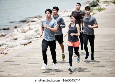 Group Of Five Young Asian Adult Men And Woman Running Training Outdoors