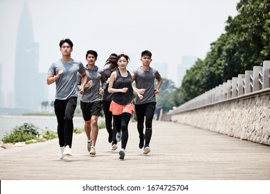 Group Of Five Young Asian Adult Men And Woman Running Training Outdoors