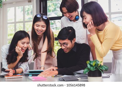 Group Of Five Young Euphoric Students Watching Exam Results In A Laptop In A Table Of An University Campus Bar.