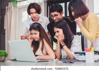 Group Of Five Young Euphoric Students Watching Exam Results In A Laptop In A Table Of An University Campus Bar.