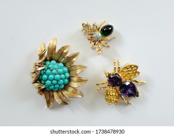 A group of flower and flies vintage brooches isolated on a white background. Top view.