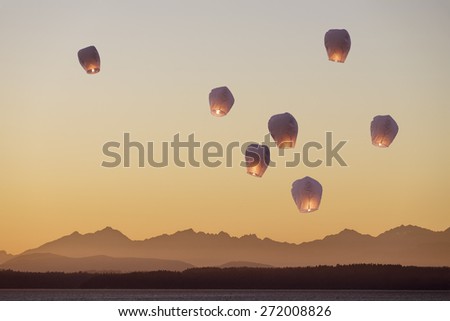 A group of flying lanterns being released into the nightsky 